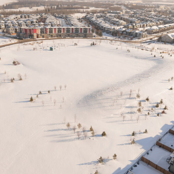 Aerial view of a snow covered community park bordered by houses in Trumpeter by Big Lake, Edmonton, Alberta.